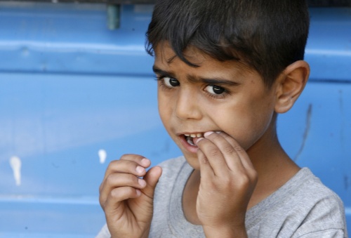 طفل عراقي يتذوّق حلوى من جندي أميركي في بغداد أمس (نيكولا سوليك - رويترز)