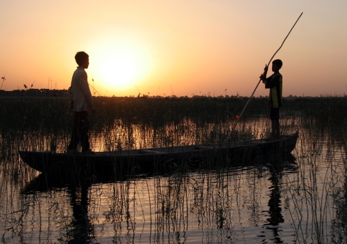 عراقيان يصطادان السمك في مستنقع في جنوب بغداد أمس (غسان الياسري - أ ب)