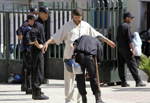 شرطي يفتّش مواطن خلال تظاهرة ضدّ الارهاب في الجزائر أمس (لوافي لاربي - رويترز)