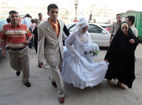 عروسان عراقيان بعد حفل زفافهما في بغداد أول من أمس (أحمد الرباي - أ ف ب)