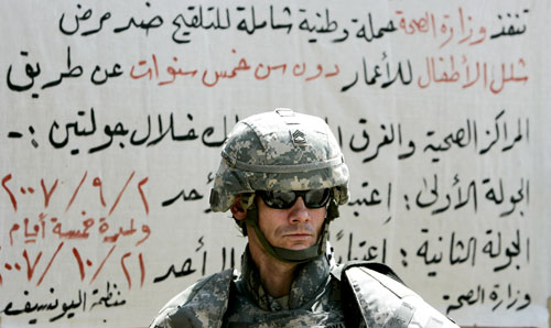 جندي أميركي يحرس مدخل مستشفى في جنوب شرق بغداد أمس (كارلوس باريا - رويترز)