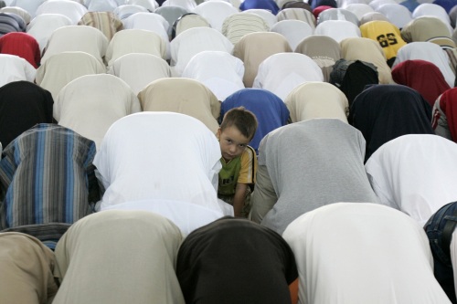 طفل عراقي بين مصلّين في أحد مساجد بغداد أمس (محمود رؤوف محمود - رويترز)