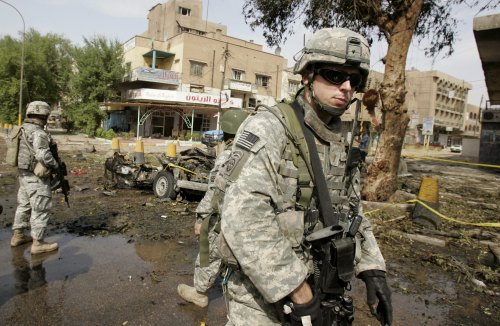 جندي أميركي عند موقع تفجير استهدف جنوداً عراقيّين في شارع السعدون في بغداد أمس (محمود محمود - رويترز)