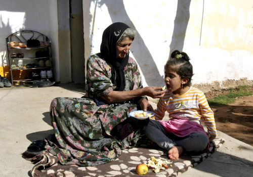نازحة كردية تُطعم طفلها بالقرب من الحدود التركية ـ العراقية أمس (خالد محمد ــ أ ب)