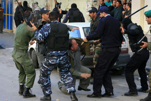 قوى الأمن الفلسطينية التابعة للسلطة تعتدي على متظاهر ضدّ «أنابوليس» في الخليل أمس (أ ف ب)