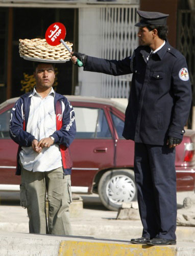 شرطي عراقي ينظّم السير في بغداد أمس (محمد رؤوف محمود ـ رويترز)