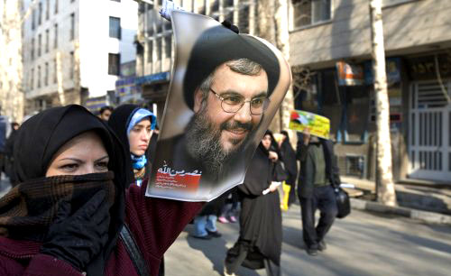 إيرانية تحمل صورة السيد نصر الله خلال تظاهرة في طهران أمس ( راهب هومافندي ـ رويترز)