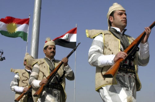 عناصر أكراد من «البشمركة» أثناء رفع العلم العراقي الجديد في أربيل أمس (أزاد لشقري - رويترز)