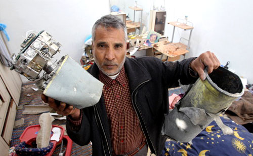 فلسطيني يحمل شظايا صاروخ إسرائيلي استهدف منزله شمال غزّة أمس (مهدي فدوش ـ أ ف ب)