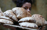 فتى مصري ينقل أرغفة خبز في القاهرة (ناصر نوري ـ رويترز)