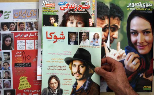 إيراني يحمل مجلات مُنع بعضها من الصدور بسبب «الانحراف الأخلاقي» في طهران أمس (عطا كناريه ـ أ ف ب)