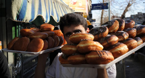 إيراني يبيع الكعك المحلّى في طهران أوّل من أمس (فريد دوفور ـ أ ف ب)