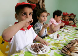 أيتام عراقيّون يتناولون الإفطار في يوم اليتيم العربي في بغداد أمس (محمود محمود ـــ رويترز)