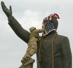 وجه تمثال صدّام يغطّيه جنديّ أميركي بعلم بلاده غداة سقوط بغداد (أرشيف)