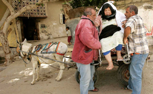 فلسطينيّان يستعينان بعربة يجرّها حمار لنقل عجوز إلى المستشفى بعد انقطاع الوقود عن غزّة أمس (إبراهيم أبو مصط
