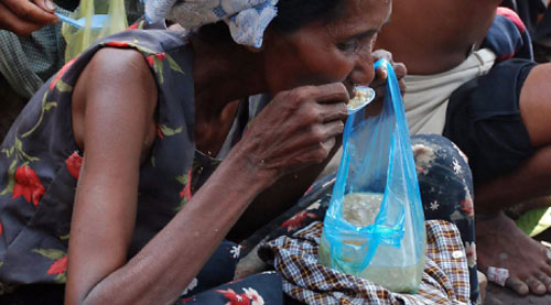 مواطنة من ميانمار تتناول ما تيسّر من طعام على أنقاض منزلها في إيراوادي، أول من أمس (أ ف ب)