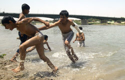 يلهون على ضفاف نهر دجلة في بغداد أمس (علي يوسف ـــ أ ف ب)