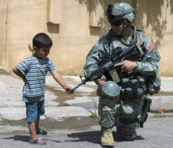 طفل عراقي يتفحّص بندقية جندي أميركي في الموصل أول من أمس (علي يوسف ـــ أ ف ب)