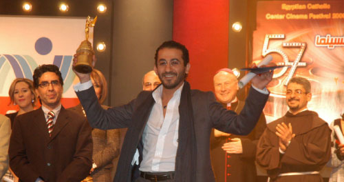 أحمد حلمي مستلماً جائزته في «المهرجان الكاثوليكي للسينما»