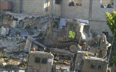 جرافة إسرائيلية تدمِّر منزلا في “مخيم عسكر” في الضفة الغربية أمس (أ ف