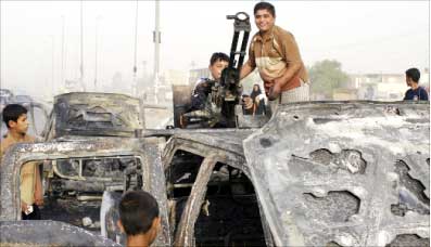 أولاد يلهون على متن آليات عسكرية عراقية أحرقها جيش المهدي في الديوانية امس (رويترز)