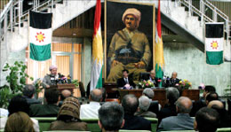 البرزاني أمام البرلمان الكردي في أربيل وخلفه علم عراقي يعود إلى الستينات إضافة إلى العلم الكردي (رويترز)