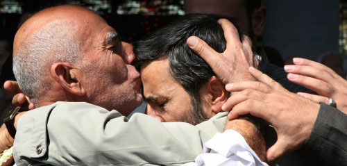 مواطن يقبِّل رأس الرئيس الايراني محمود أحمدي نجاد خلال صلاة الجمعة في طهران أمس (رويترز)