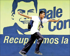 فتى يلعب امام صورة للمرشح الرئاسي رافائيل كوريا في ريكريو في الاكوادور امس (اب)