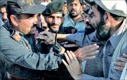 ناشط باكستاني يشتبك مع ضابط شرطة خلال احتجاج في باجور امس (اف ب)