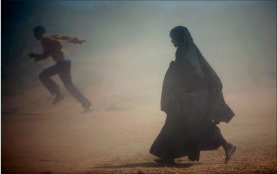 صوماليًة تركض للاحتماء من عاصفة رملية ضربت أحد مخيًمات اللاجئين قرب الحدود الكينيّة أمس (رويترز)