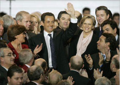 ساركوزي وإلى جانبه إيليو ماري يحيّي زملاءه خلال المهرجان الحزبي في باريس أمس (أ ب)