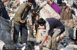 الفقراء يجمعون الطعام من القمامة في مدينة الصدر أمس (رويترز)
