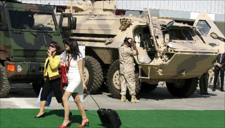 امرأتان أمام مدرعتين خلال معرض السلاح «إيدكس 2007» في أبو ظبي في 18 شباط الماضي (أ ف ب)