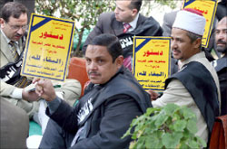 نوّاب من كتلة «الإخوان المسلمين» يحتجّون خارج مبنى البرلمان المصري في القاهرة أمس (إي بي أي)