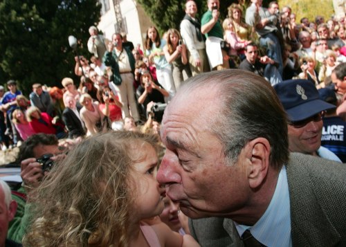 شيراك يقبل طفلة في عيد الفصح في «بورم دو ميموزا» (أرشيف - فيليب لورانسون- رويترز)