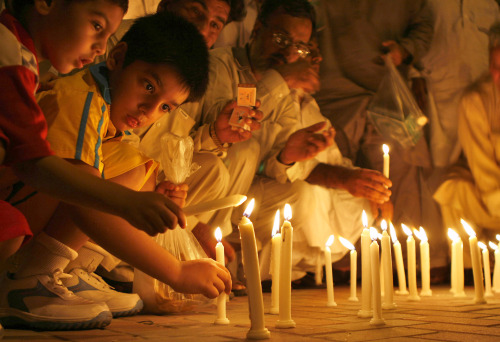 أطفال باكستانيّون يصلّون لضحايا «المسجد الأحمر» في لاهور أمس (ك. تشودري - أ ب)