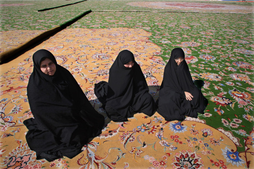 ايرانيتان تجلسان على سجاد فاخر في طهران امس (عطا كينار - أ ف ب)