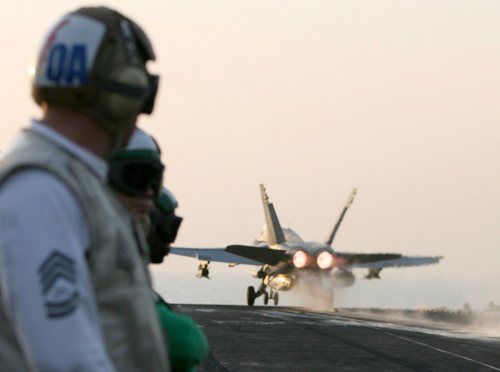 عناصر من طاقم حاملة الطائرات الأميركيّة «يو أس أس إنتربرايز» يراقبون إقلاع مقاتلة «أف - 18» في الخليج العربي الشهر الماضي (مازن مهدي - إي بي أي)