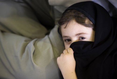 فتاة إيرانية تغطي وجهها في طهران أمس (مورتيزا نيكوبازل - رويترز)
