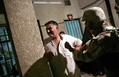 والد عراقي أوقفته القوّات الأميركية المحتلّة في ظفرانيه جنوب بغداد أمس (كارلوس باريا - رويترز)
