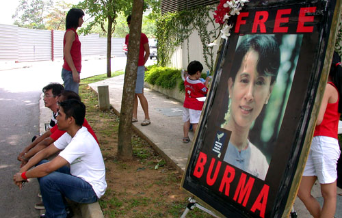 متظاهرون بالقرب من صورة سو كي أمام سفارة ميانمار في سنغافورة أمس (أيان تيمبرلايك
