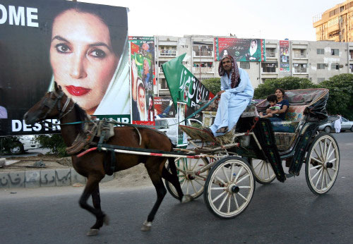 باكستاني قرب ملصق لصورة بوتو في كراتشي أمس (بيدرو أوغارتيه ــ أ ف ب)