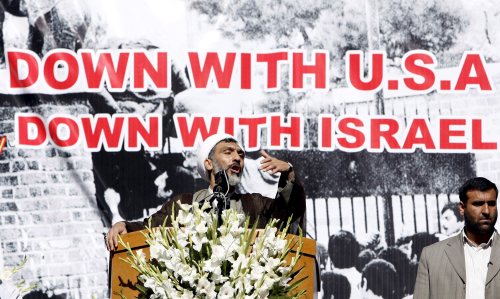 بور محمّدي وخلفه شعارات مندّدة بالولايات المتحدة وإسرائيل في طهران أمس (طاهر كناريه ـ إي بي أي)