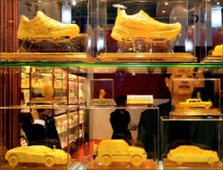 أحذية ومجسّمات مصنوعة من الذهب خلال معرض دولي في بكين أوّل الشهر الجاري (ت. كون - أ ف ب)