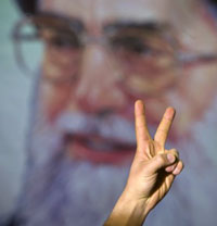 شارة النصر أمام صورة الخميني في الذكرى الـ29 لانتصار الثورة في طهران أول من أمس (مورتيزا نيكوبازل ـ رويترز)