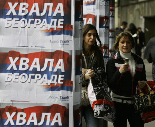 صربيّتان تسيران قرب ملصق انتخابي وزّعه تاديتش يكتب فيه: شكراً بلغراد (سرجان إيليتش ـ أ ب)