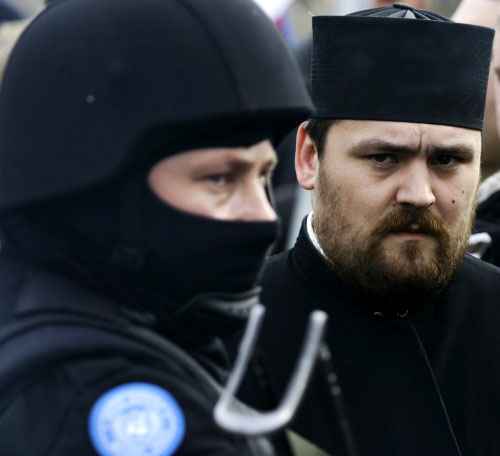رجل دين صربي يتظاهر ضدّ استقلال كوسوفو على الحدود بين الدولتين أمس (سرجان إليتش ـ أ ب)