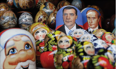 ألعاب وزينة تتوسّطها صورتا بوتين وميدفيديف في مدينة بطرسبورغ أمس (ألكسندر ديميانشوك ـ رويترز)