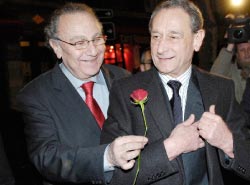 رئيس بلديّة إحدى دوائر باريس بيار أيدنباوم يقدّم وردة إلى الاشتراكي برتران دولانو (رويترز)