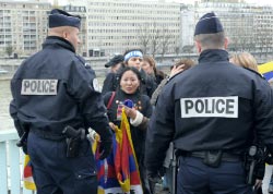 شرطيّان فرنسيّان يمنعان مناصرين لإقليم التيبت من إعاقة طريق الشعلة الأولمبيّة في باريس الأسبوع الماضي (إري